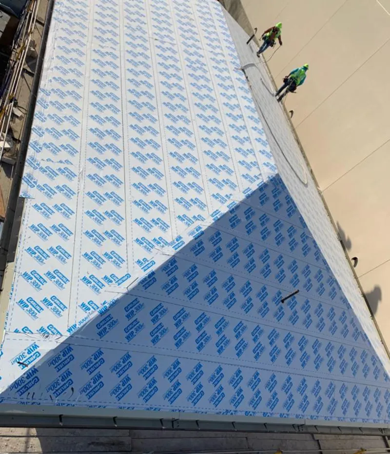 Professional roofers installing underlayment on a metal roof in Collegedale